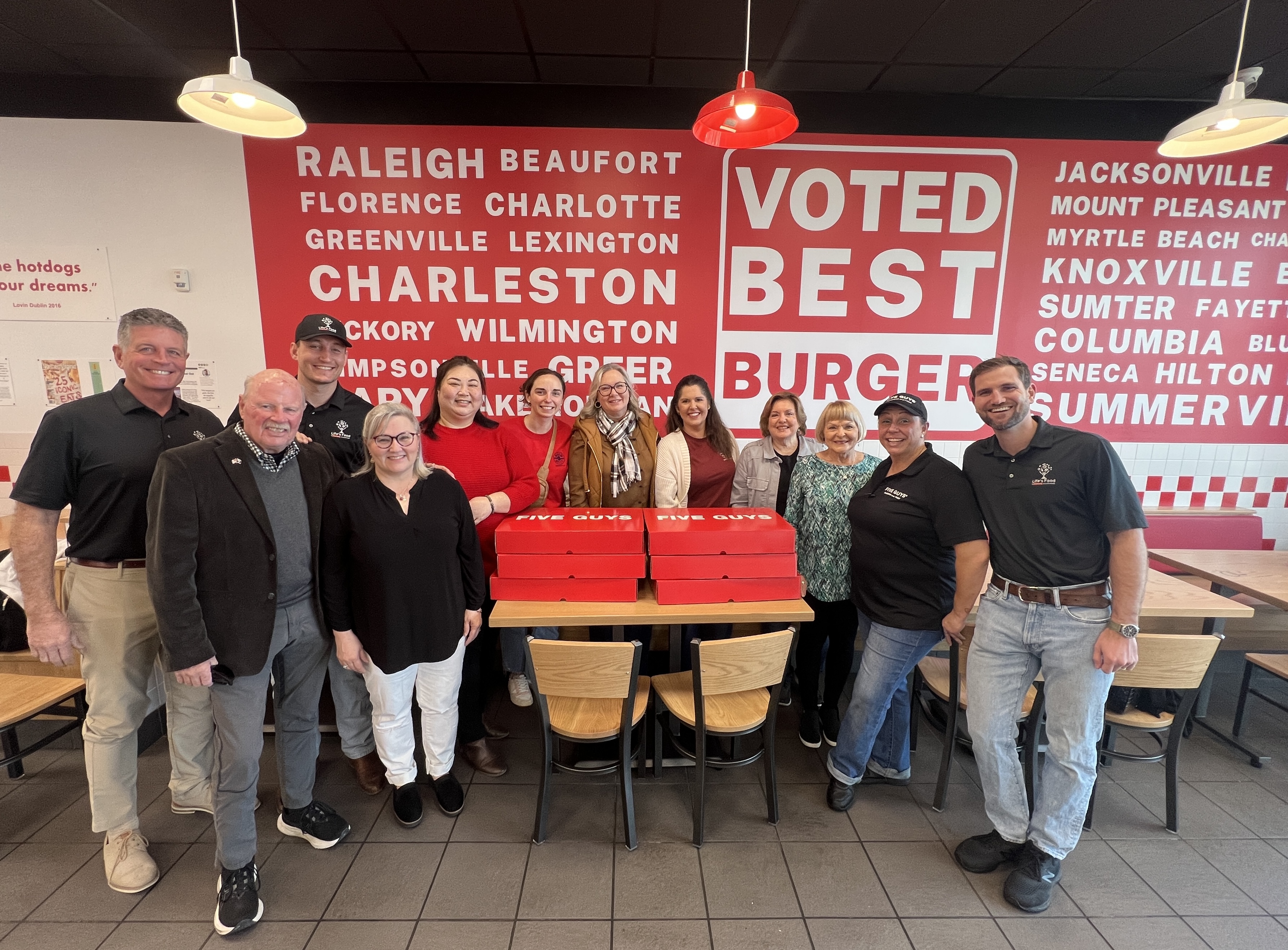 a group  of people standing around burgers